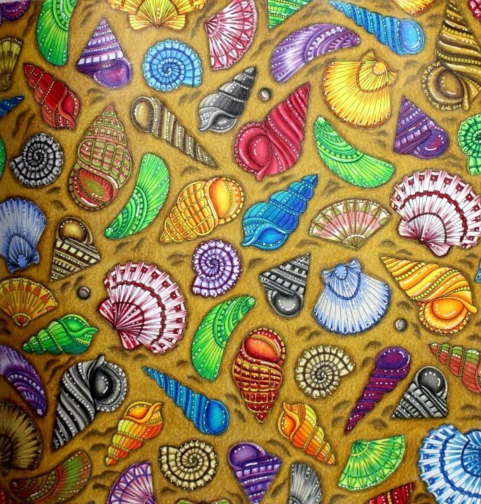 The finished Lost Ocean seashell page: spiral, cone and fan-shaped shells in red, purple, blue, turquoise, green, yellow, orange and grey with white highlights, scattered on golden ochre sand