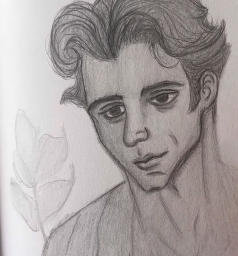 Pencil drawing of a young man with wavy hair, dark eyes looking down, an open shirt and faint leaves in the background